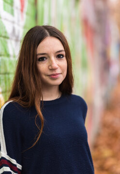 Fashion Portrait Of An 18 Year Old Red Haired Pritty Girl Standing Against A Wall