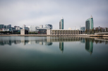 Fototapeta na wymiar Lisbon / Portugal - 12 28 2018: Panoramic view of modern buildings and skyscrapers reflecting in the calm water of a pond