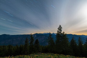 Stars and clouds streaking across the sky at night