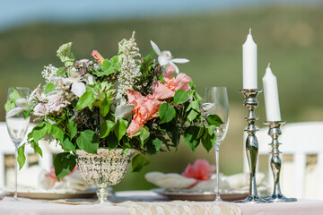 Elegant Outdoor Table Setting with Candles and Fresh Flowers