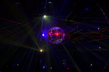 Mirrored Disco Ball and bright beams at the night party. Party attribute reflects Lazer lights....