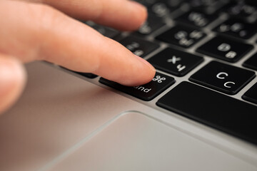 Fototapeta na wymiar Hand pressing command key on modern laptop keyboard. Command sign and symbol close-up