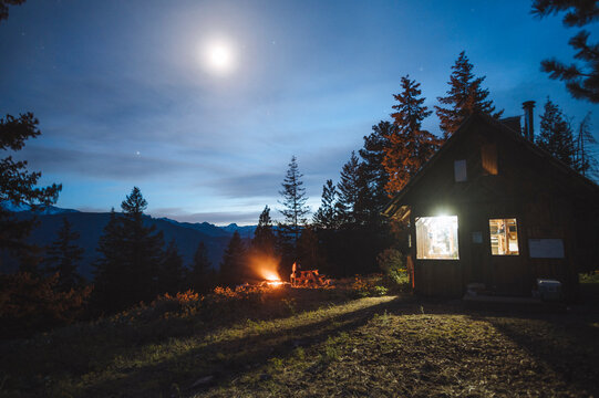 Sitting around a campfire at a cabin in the mountains