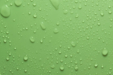 Obraz na płótnie Canvas Green pastel water drops on light shiny surface