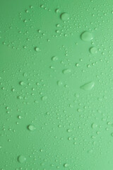 Green pastel water drops on light shiny surface