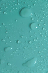 Blue pastel water drops on light shiny surface