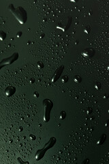 Green metal water drops on dark shiny matallic surface