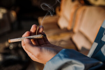 Close-up of the hands of a young boy holding a marijuana cigarette