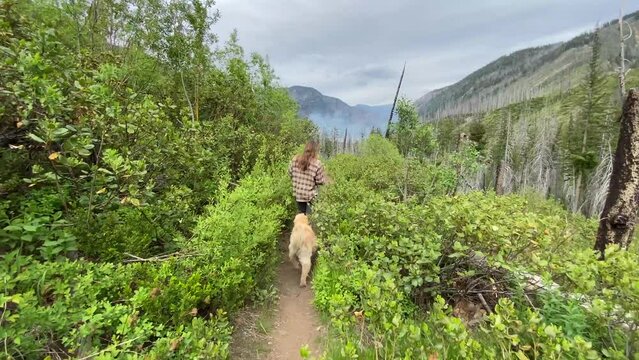 Female hiking on a trail with their dog in the North Cascades
