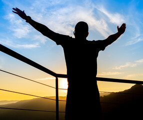 silhouette of a man raising his arms to the sky © Isaac
