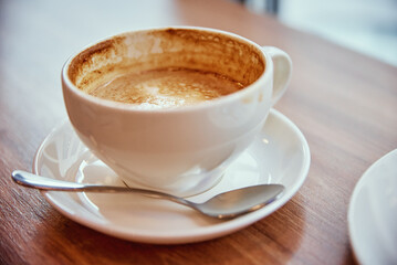 Cup of coffee on cafe table near window, breakfast at public place