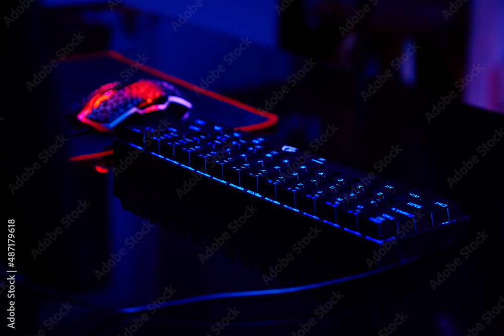 Poster pc with rgb keyboard for gaming computer video games with neon colored background, dark room with ga