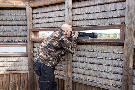 A bird photographer in a hide