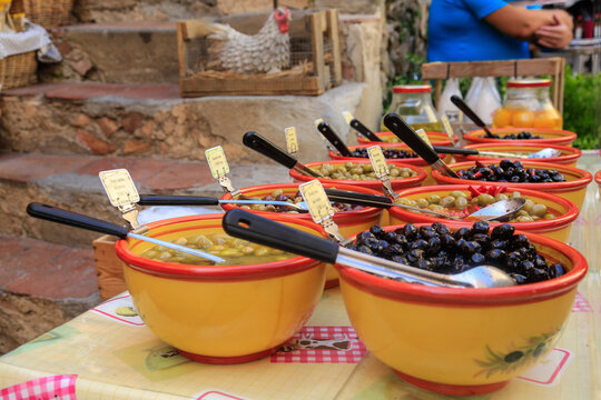 Fresh olives beautifully presented in ceramic bowls at the market in Saint-Tropez, Provence, France, blurred background
