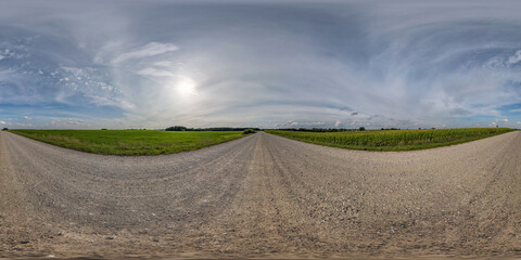 360 hdr panorama on no traffic yellow sand gravel road among fields with overcast sky with white clouds  in equirectangular spherical projection, VR AR content.  seamless
