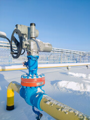 Gate valve with handwheel and electric drive. Covering the section of the condensate pipeline. The concept of oil, gas industry. Industrial site background.
