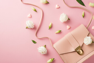Top view photo of woman's day composition pink leather purse small hearts and white prairie gentian flower buds on isolated pastel pink background with copyspace
