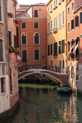 Fototapeta na wymiar Boat and bridge in a canal, Venice, Italy