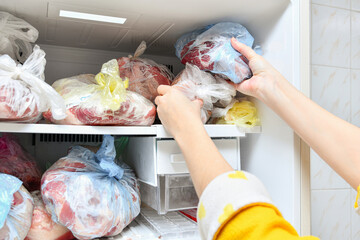The freezer is filled with frozen food. Meat, lard, and other semi-finished products are laid out in bags for long-term storage in a refrigerator.