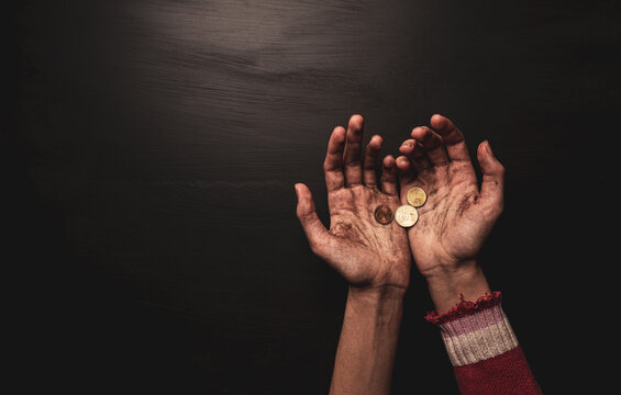 Poverty - kid begging for money. Dirty skinny beggar child’s hands with coins on black.