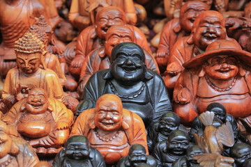 Laughing black buddha figure surrounded by other religious figures as tourist souvenirs at the Ubud...