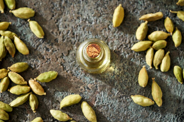 A bottle of essential oil with cardamom seeds