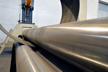 Sheet metal bending on an industrial roller machine.