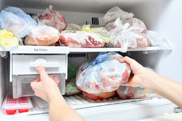 The freezer is filled with frozen food. Meat, lard, and other semi-finished products are laid out...