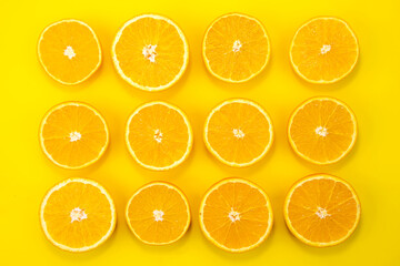 Fresh orange slices on yellow background. Flat lay. Top view.