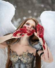 Portrait of an angel girl with wings and a bloodstained face