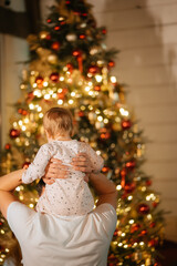 Feet of a little boy on the background of a Christmas tree