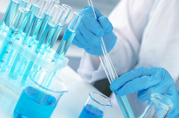 Hands of a scientist with a laboratory pipette. Equipment for chemical experiments. Scientist doing...