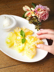 Plate with grilled pineapple slices and vanilla ice cream on wood background. Fruit yellow dessert.