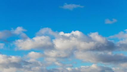 Picturesque blue sky with white fluffy clouds in sunny weather