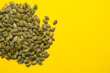 Pumpkin seed on a yellow background close-up.