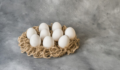 white eggs in a nest on a gray background. easter eggs. Copy space