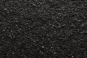 Texture of black volcanic sand for background. Black Sand beach macro photography. Close-up view of...