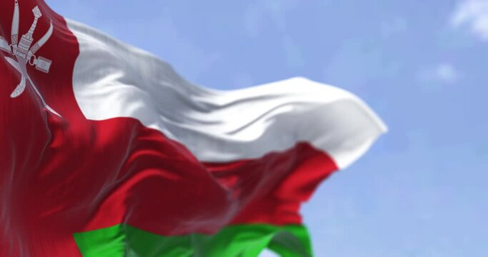 Detail of the national flag of Oman waving in the wind on a clear day. Democracy and politics. Patriotism. Selective focus. Western Asian country. Seamless slow motion looping