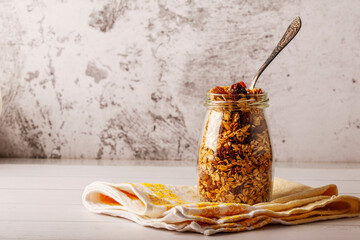 Granola bowl with raisins, nuts and fresh berries. Homemade crunchy granola on grey concrete...