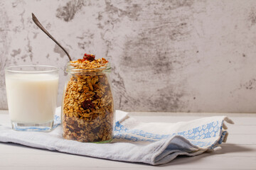 Granola bowl with raisins, nuts and fresh berries. Homemade crunchy granola on grey concrete...