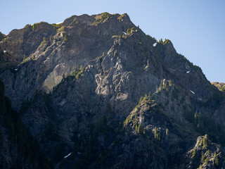 Sunrise on the mountains towering over Enchanted Valley in Olympic National Park, forest covered ridges.