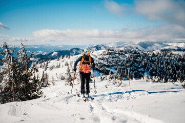 Mountaineer backcountry ski walking ski woman alpinist in the mountains. Ski touring in alpine...