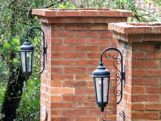 Two wall garden lights on two brick pillars