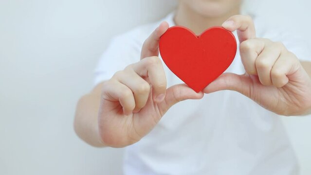 Children's hands holding heart shape love and health symbol.