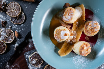 fresh cheese pancakes with banana and peanut butter, mango and raspberry sauce