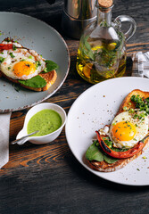 delicious and appetizing bruschetta with fried eggs and herbs for breakfast