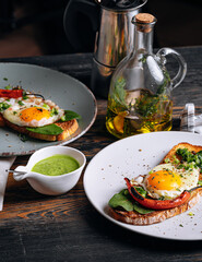 delicious and appetizing bruschetta with fried eggs and herbs for breakfast