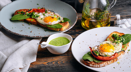 delicious and appetizing bruschetta with fried eggs and herbs for breakfast
