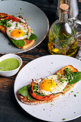 delicious and appetizing bruschetta with fried eggs and herbs for breakfast