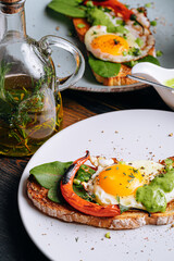 delicious and appetizing bruschetta with fried eggs and herbs for breakfast